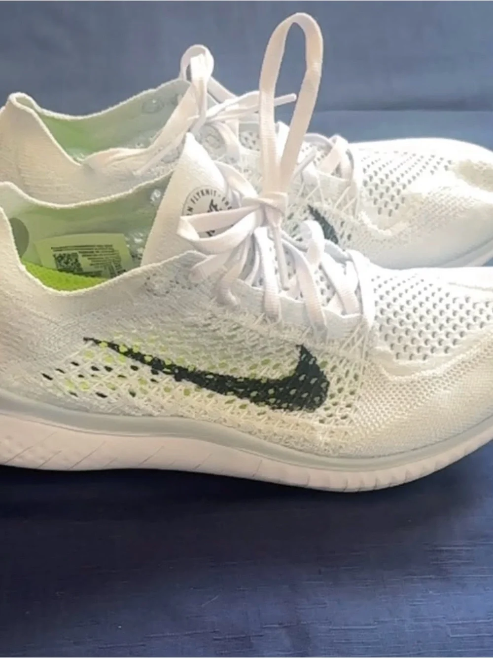 Nike Women’s White Flyknit Sneakers with Black Swoosh and Lime Accents